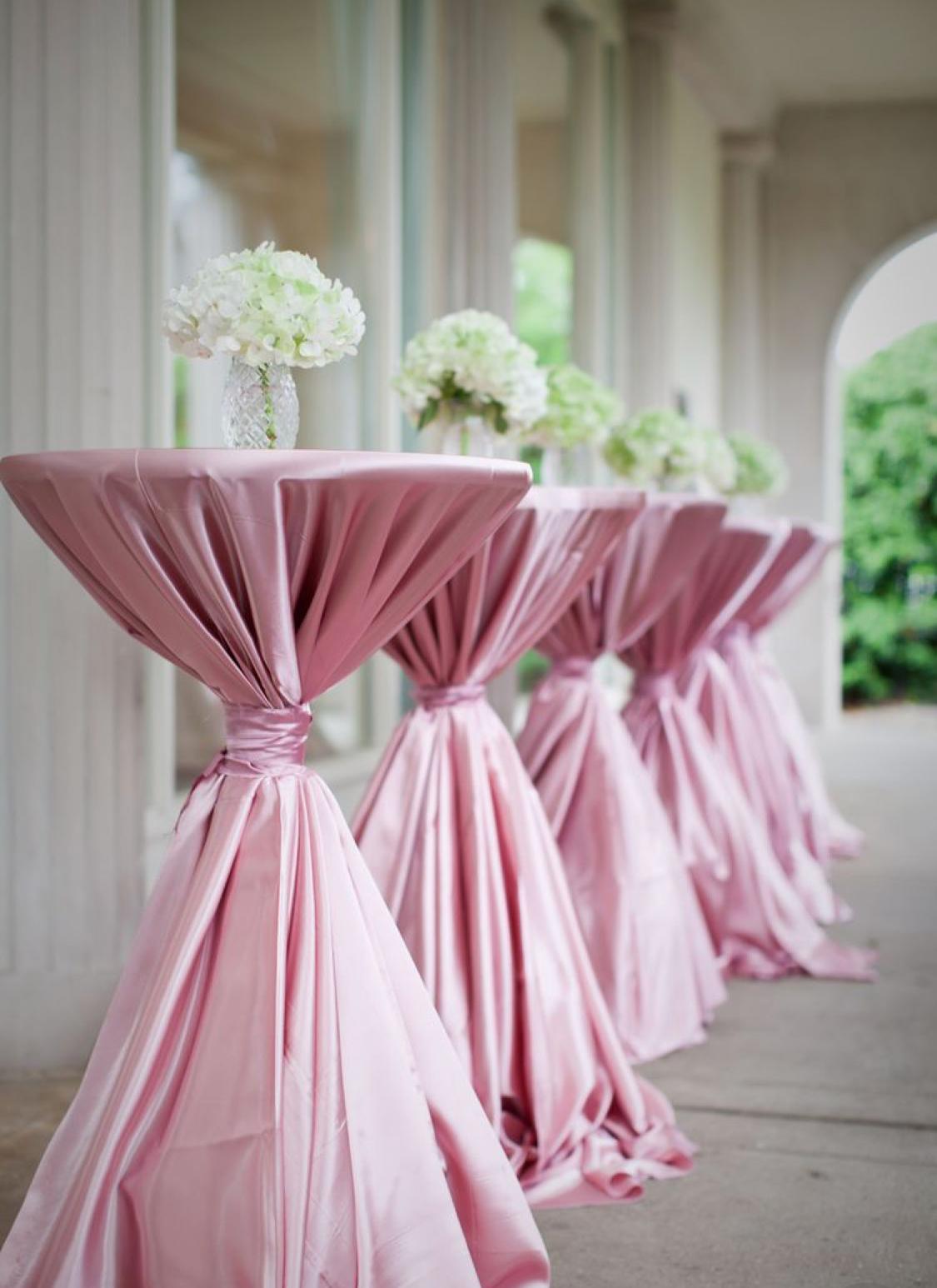 Draped cocktail tables set for a wedding reception